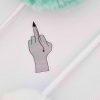 A Sticker, It depicts a hand making an obscene gesture with the middle finger extended, which is bleeding, creating a red drip trail downwards. Flanking the hand are two fluffy pens, one green and one white.